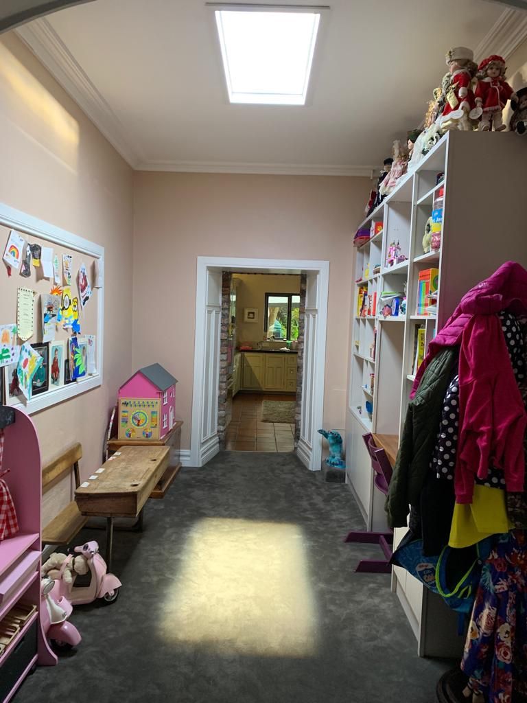 Static cloud skylight above a children's playroom hallway with dynamic sky skylight set to daylight mode. As a dynamic sky panel, it also offers slow-moving clouds, an optional starry night mode after dark, and an adjustable colour temperature from crisp all-white daylight through to a warmer all-warm tone, letting the space be tuned through the day and evening rather than staying fixed like a static image.
