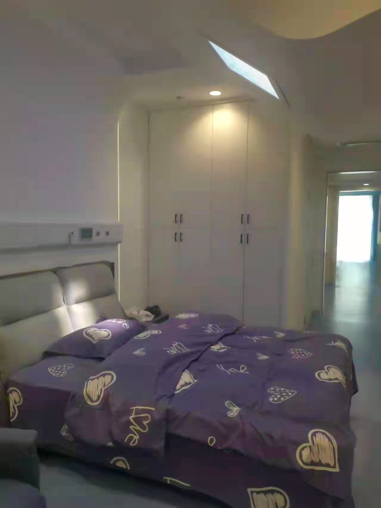 Second angle of static cloud skylight positioned above a hospital light-therapy patient bedroom directed at the patients head to give direct sunlight therapy to regulate circadian rythem to support the patient's sleep/wake cycle.
