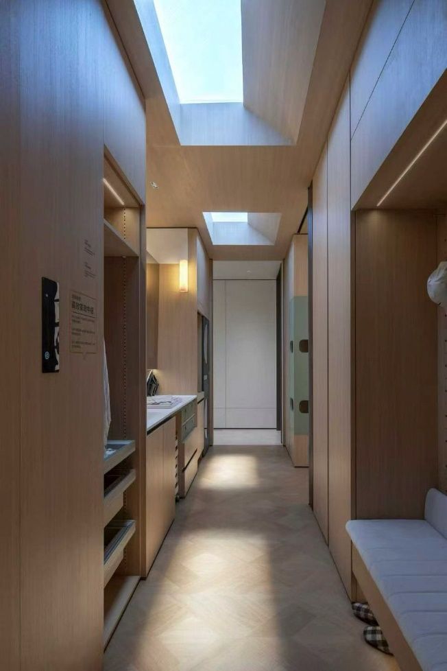 Second angle of the same laundry/utility corridor, showing the blue sky skylight lighting the full run of joinery.