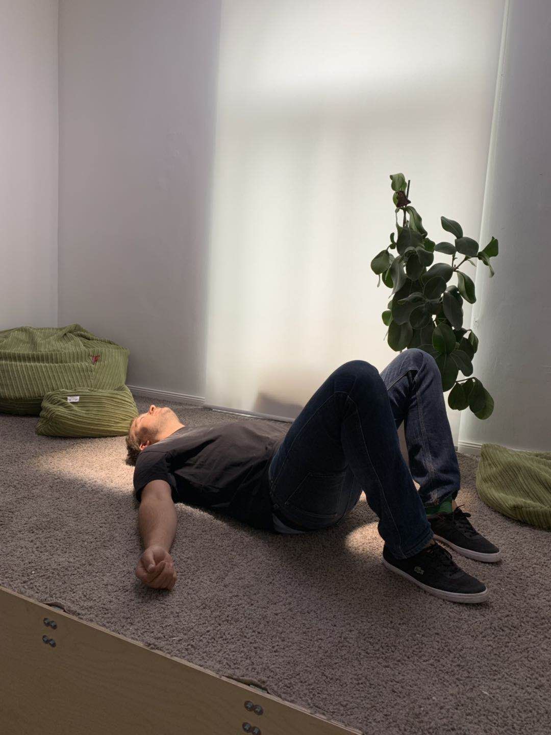 A visitor lies beneath the same surface-mounted skylight to show the beam of natural-feeling light it casts into the room.