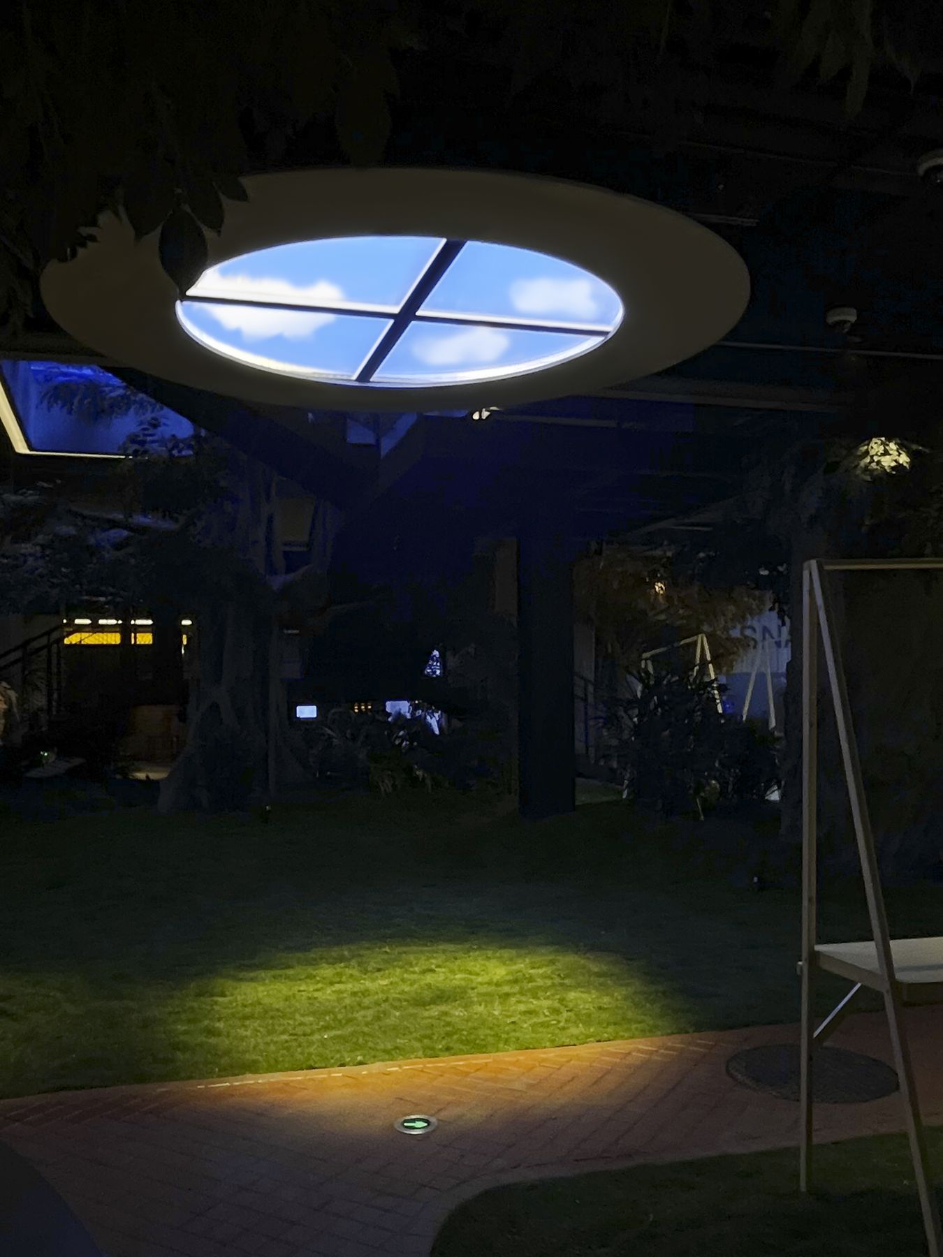 Four SOL-1212 static cloud skylights suspended together behind custom circular framing, creating a single large-format round skylight feature rather than a visible grid of square panels. Static cloud was chosen over dynamic sky here so the feature reads as a calm, consistent architectural element rather than drawing attention with movement.