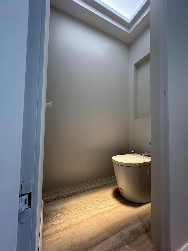 Blue sky artificial skylight above a powder room, warm light