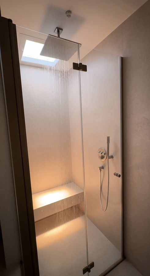 Blue sky 600x600 skylight with IP54 installed within walk-in rainfall shower, bringing daylight into an internal, window-free ensuite. Set to warm 3000K.