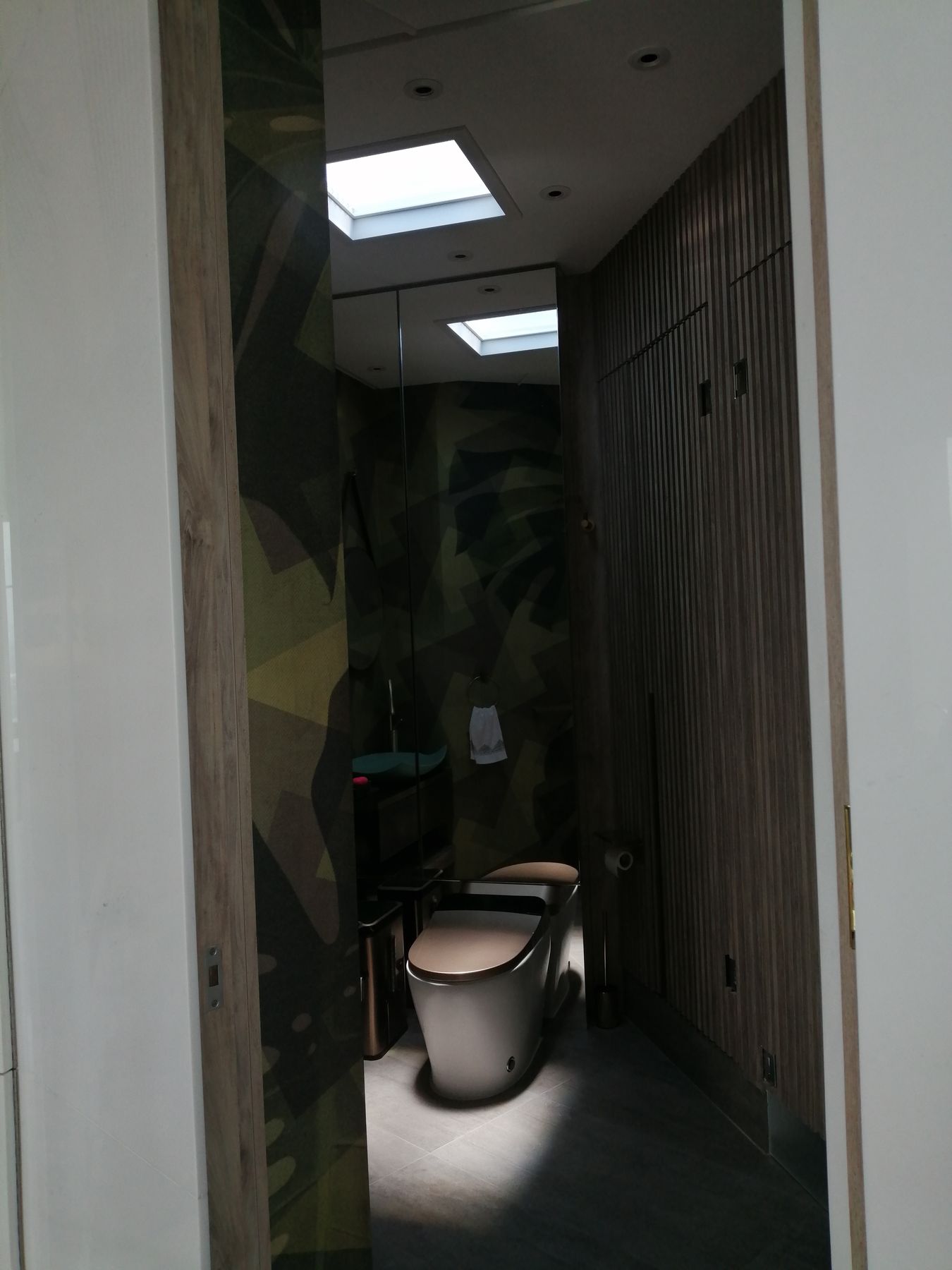 Blue sky skylight above toilet in powder room set to day light.