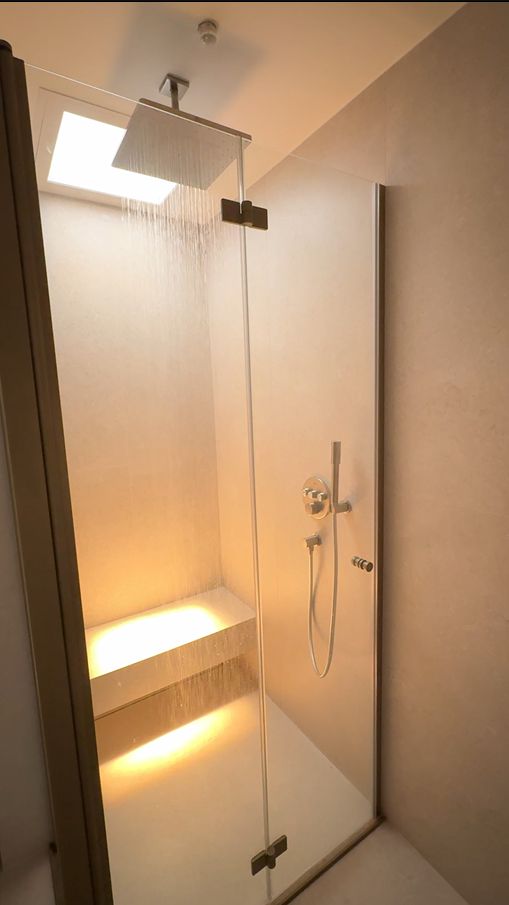 Blue sky 600x600 skylight with IP54 installed within walk-in rainfall shower, bringing daylight into an internal, window-free ensuite. Set to warm 2500K.