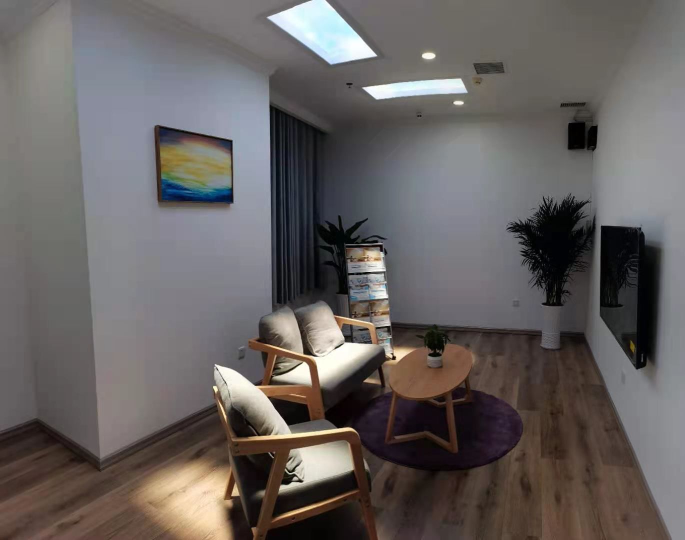 Two static cloud skylights above a homely light-therapy lounge, furnished like a living room to make daily light-therapy sessions feel less clinical for patients.
