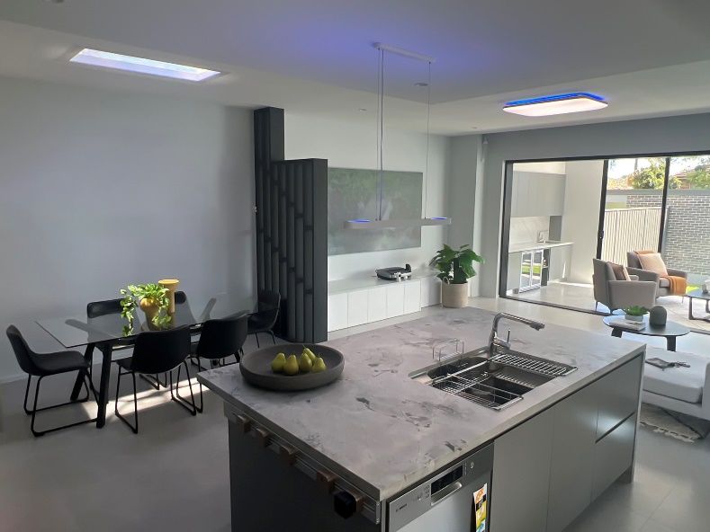 Artificial skylight above an open-plan kitchen island and dining area