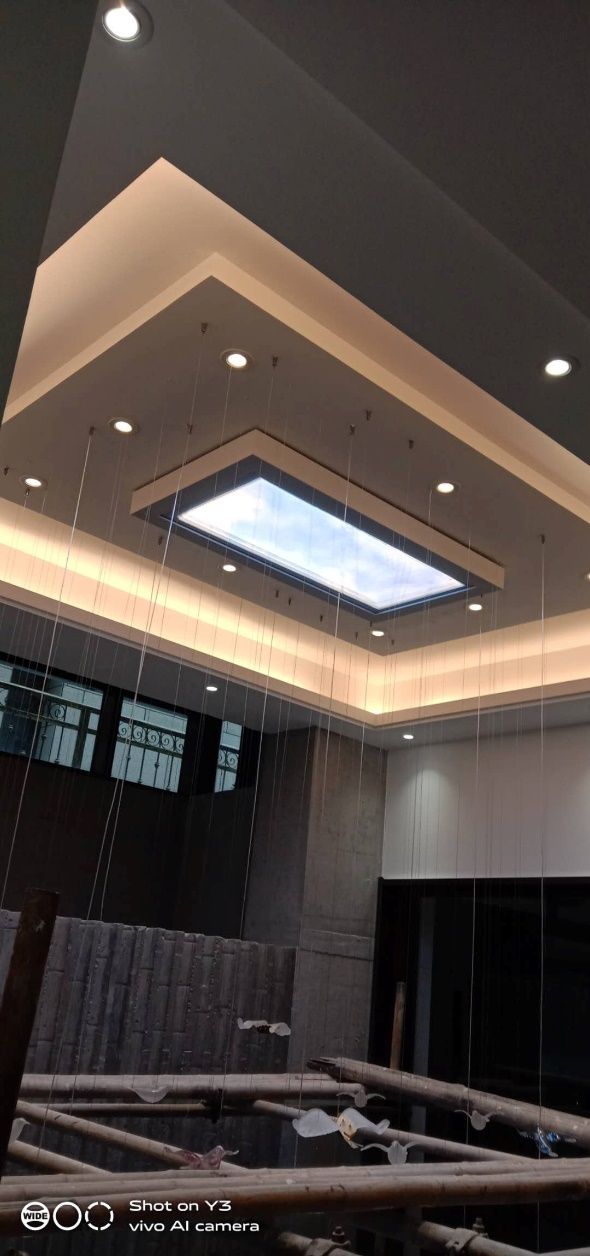 Artificial skylight above a double-height stairwell void during fit-out