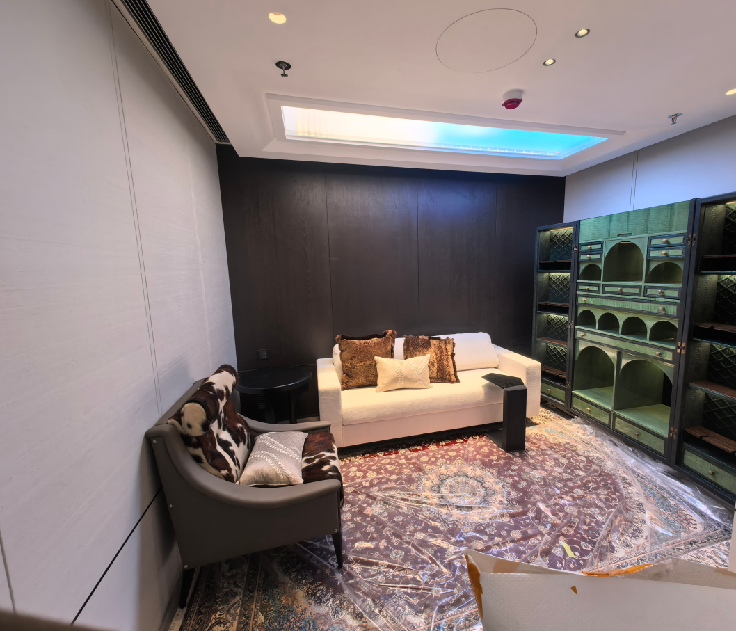 Artificial skylight above a dark-panelled wine lounge