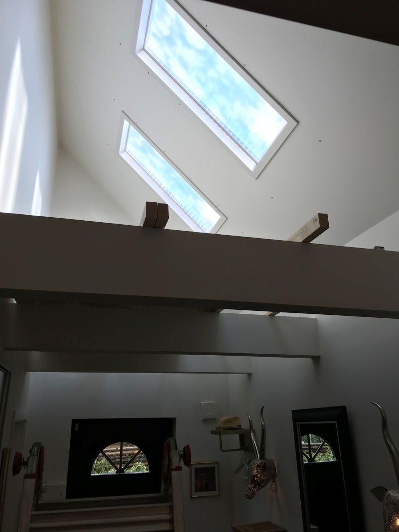 Two dynamic sky artificial skylights in a racked vaulted timber entry ceiling
